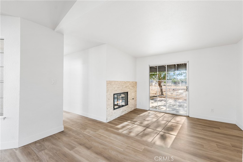 40251 Fieldspring Street Palmdale, CA 93591 - Photo 17 of 45 a view of a livingroom with wooden floor and a fireplace