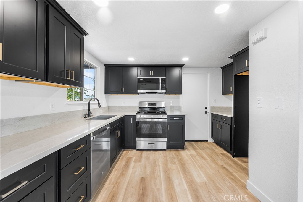 40251 Fieldspring Street Palmdale, CA 93591 - Photo 19 of 45 a kitchen with stainless steel appliances granite countertop a sink stove and refrigerator