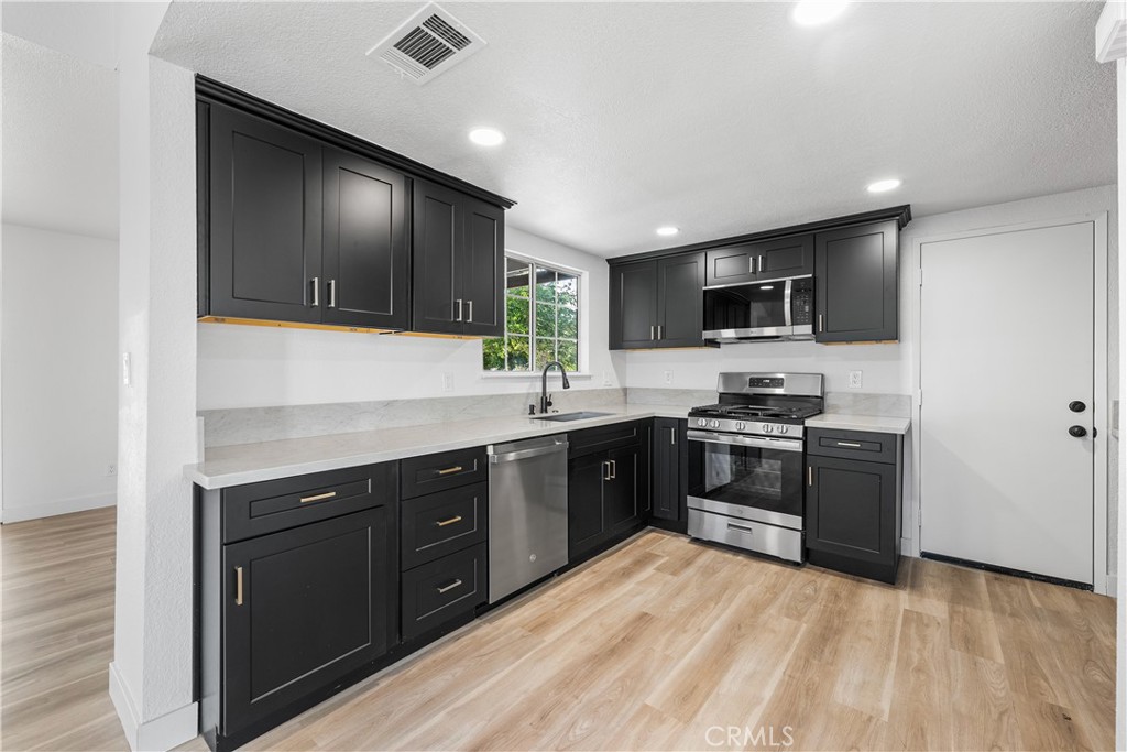 40251 Fieldspring Street Palmdale, CA 93591 - Photo 20 of 45 a kitchen with stainless steel appliances kitchen island granite countertop a stove sink and refrigerator