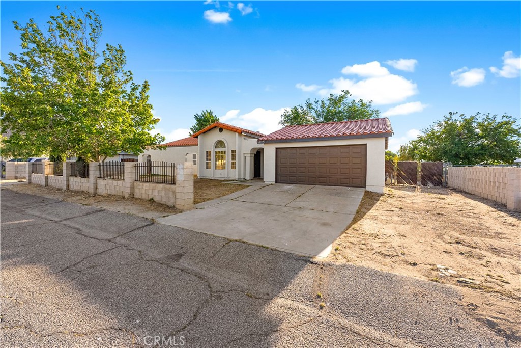 40251 Fieldspring Street Palmdale, CA 93591 - Photo 2 of 45 a front view of a house with a yard and garage
