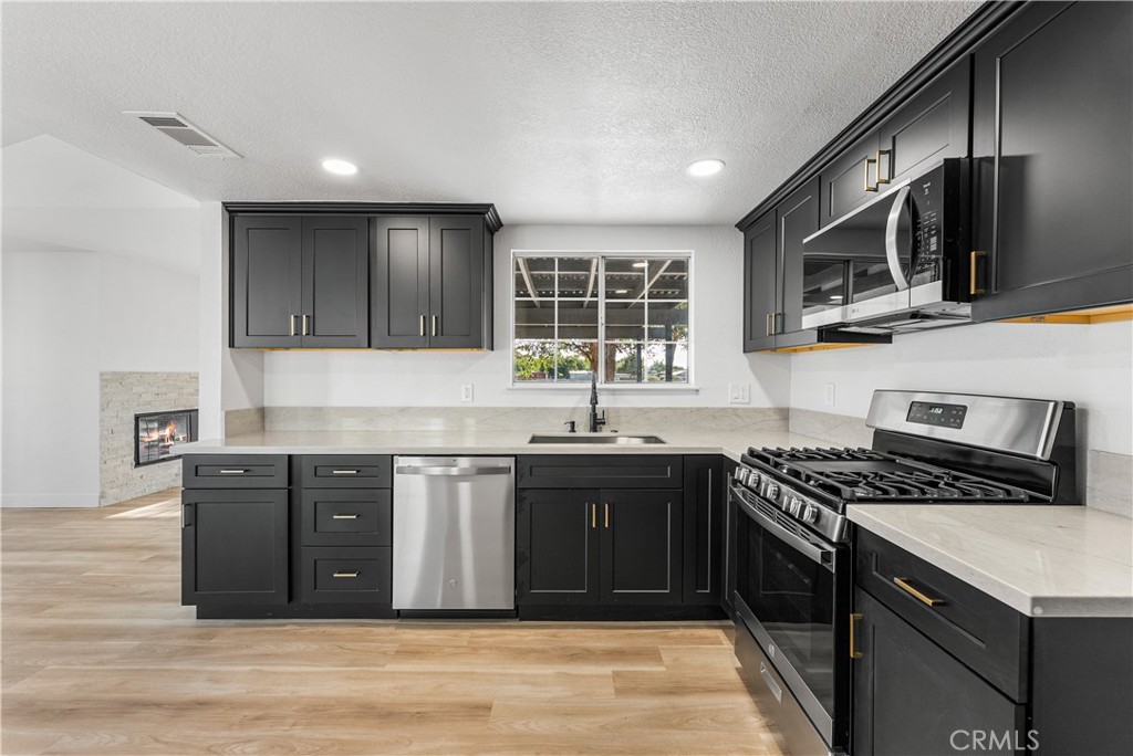 40251 Fieldspring Street Palmdale, CA 93591 - Photo 22 of 45 a kitchen with stainless steel appliances granite countertop a stove and a sink