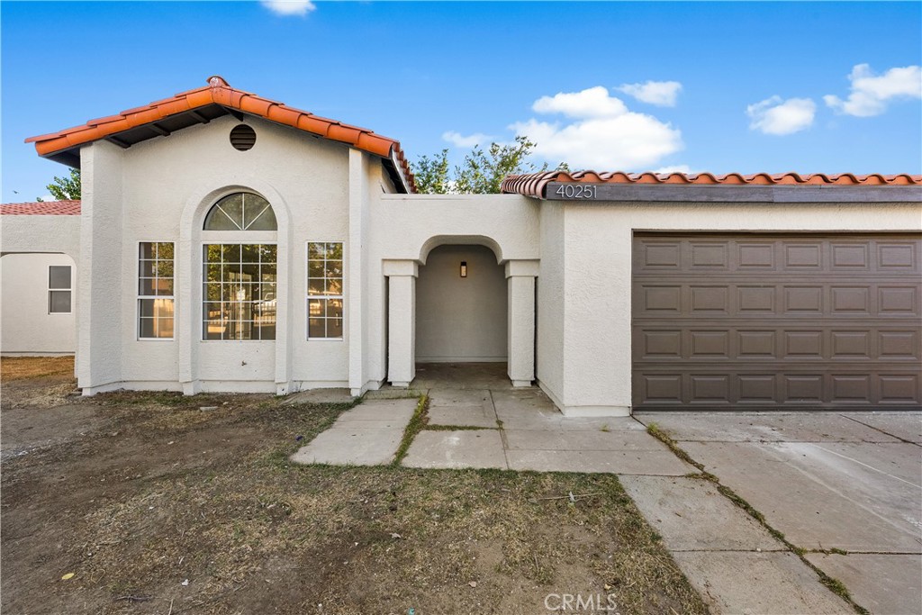 40251 Fieldspring Street Palmdale, CA 93591 - Photo 3 of 45 a view of a white house with a large windows and a yard