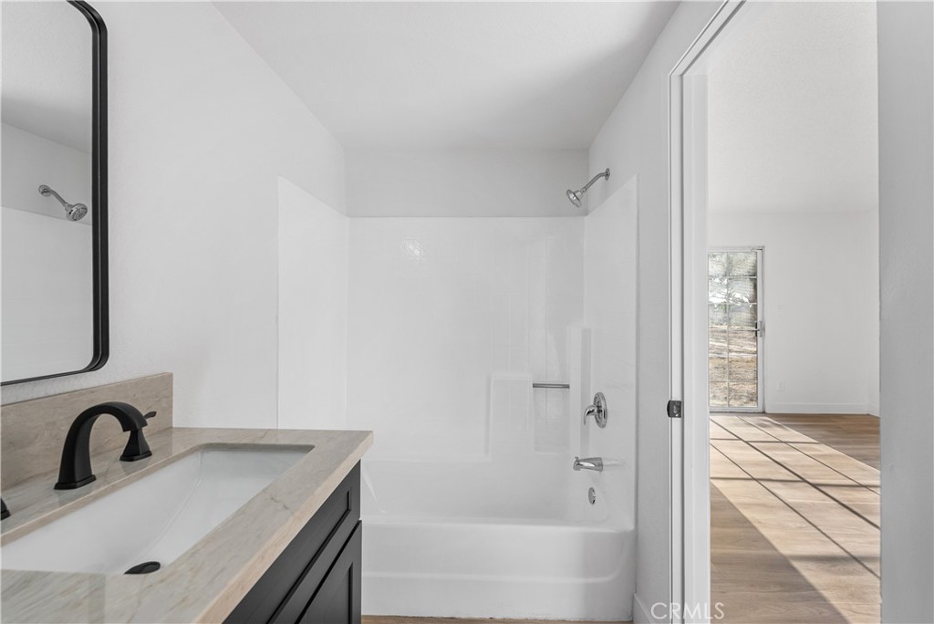 40251 Fieldspring Street Palmdale, CA 93591 - Photo 35 of 45 a bathroom with a sink a mirror and a bathtub