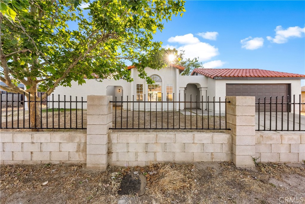 40251 Fieldspring Street Palmdale, CA 93591 - Photo 6 of 45 a view of a white house with a large window and wooden fence