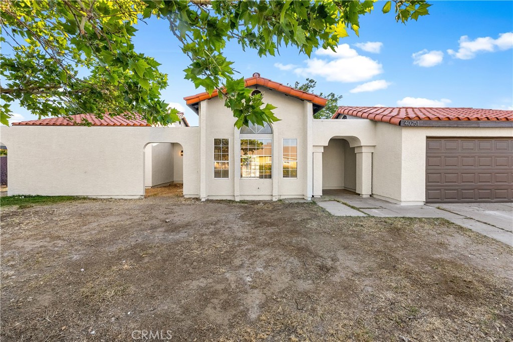 40251 Fieldspring Street Palmdale, CA 93591 - Photo 7 of 45 a view of a white house with a yard and garage