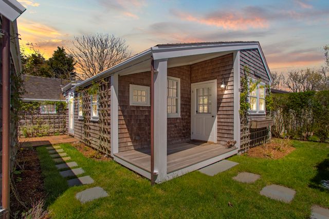 a view of a small house with backyard