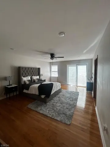 a large bedroom with a bed and wooden floor