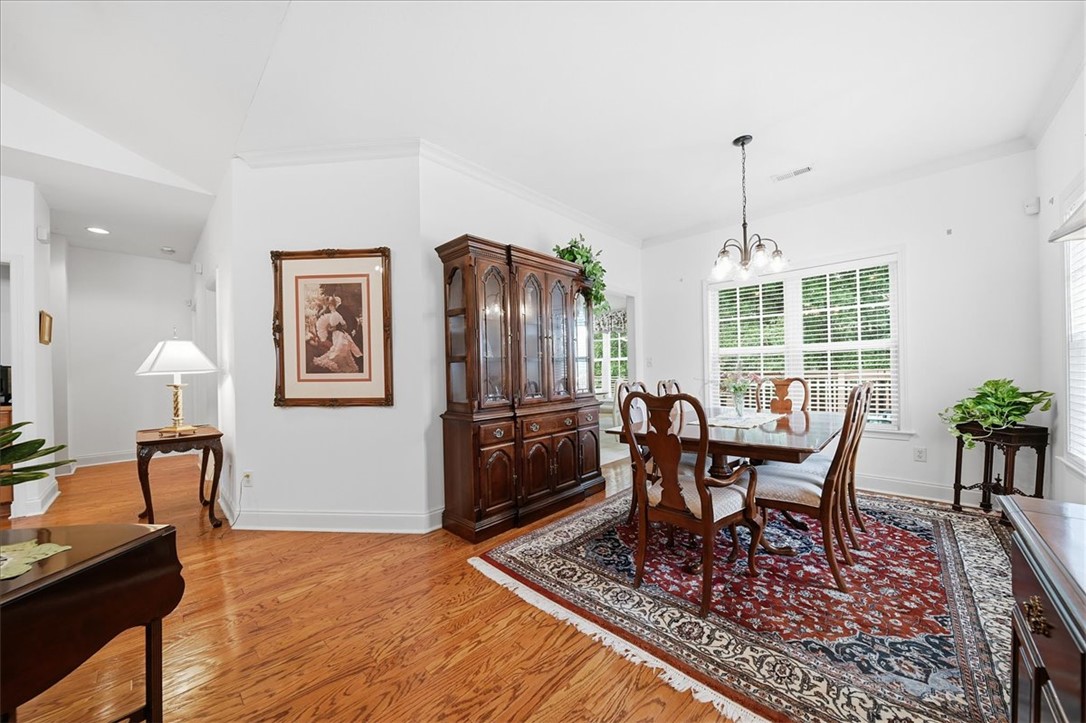 112 Elliott Circle Anderson, SC 29621 - Photo 8 of 35 Natural light illuminates rich hardwood floors, creating an inviting ambiance in this dining room.