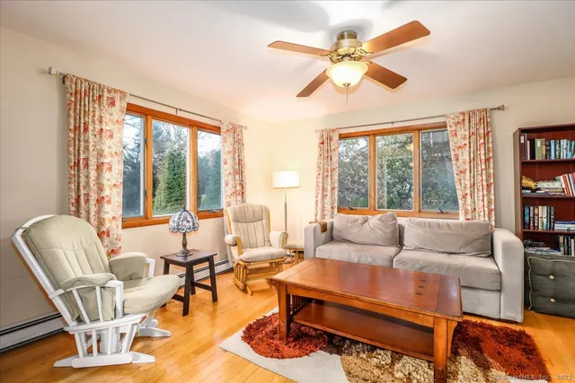 a living room with furniture a flat screen tv and a window