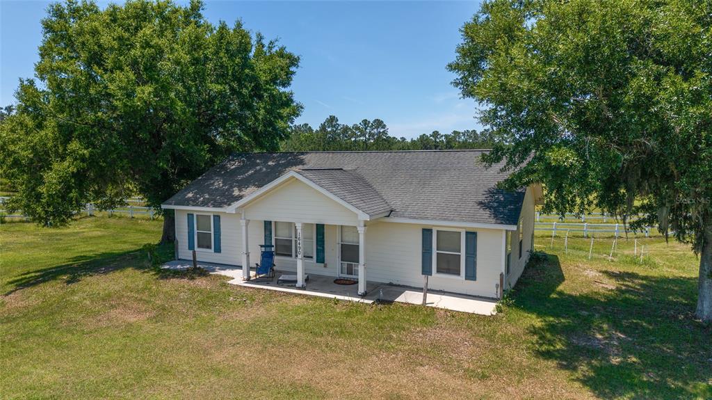 a view of a house with a swimming pool and a yard