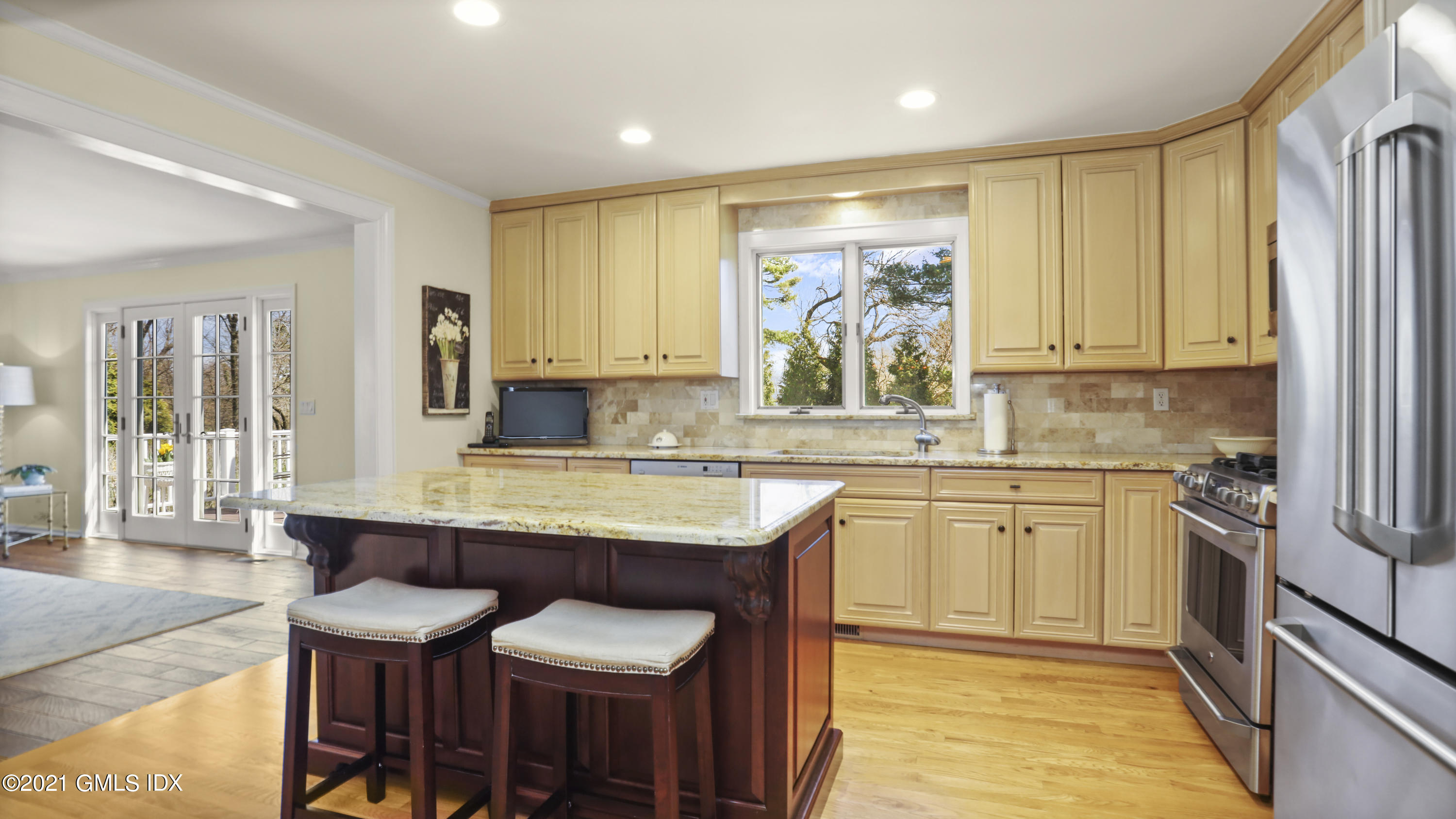 4 Norias Road Greenwich, CT 06830 - Photo 17 of 44 a kitchen with stainless steel appliances granite countertop a table chairs sink and cabinets