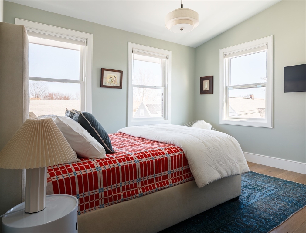 11 Tannery Brook Row, Unit 3 Somerville, MA 02144 - Photo 17 of 20 a bedroom with a bed and wooden floor