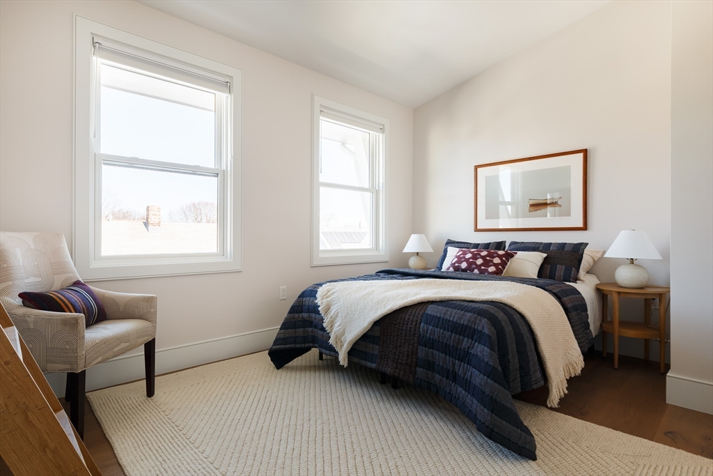 11 Tannery Brook Row, Unit 3 Somerville, MA 02144 - Photo 18 of 20 a spacious bedroom with a bed and a couch next to a window