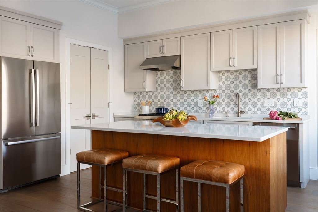 11 Tannery Brook Row, Unit 3 Somerville, MA 02144 - Photo 3 of 20 a kitchen with stainless steel appliances granite countertop a sink and a refrigerator
