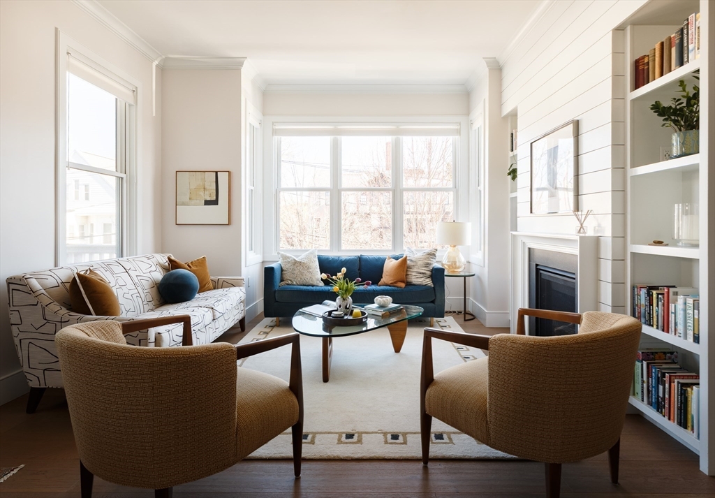 11 Tannery Brook Row, Unit 3 Somerville, MA 02144 - Photo 8 of 20 a living room with fireplace furniture and a large window