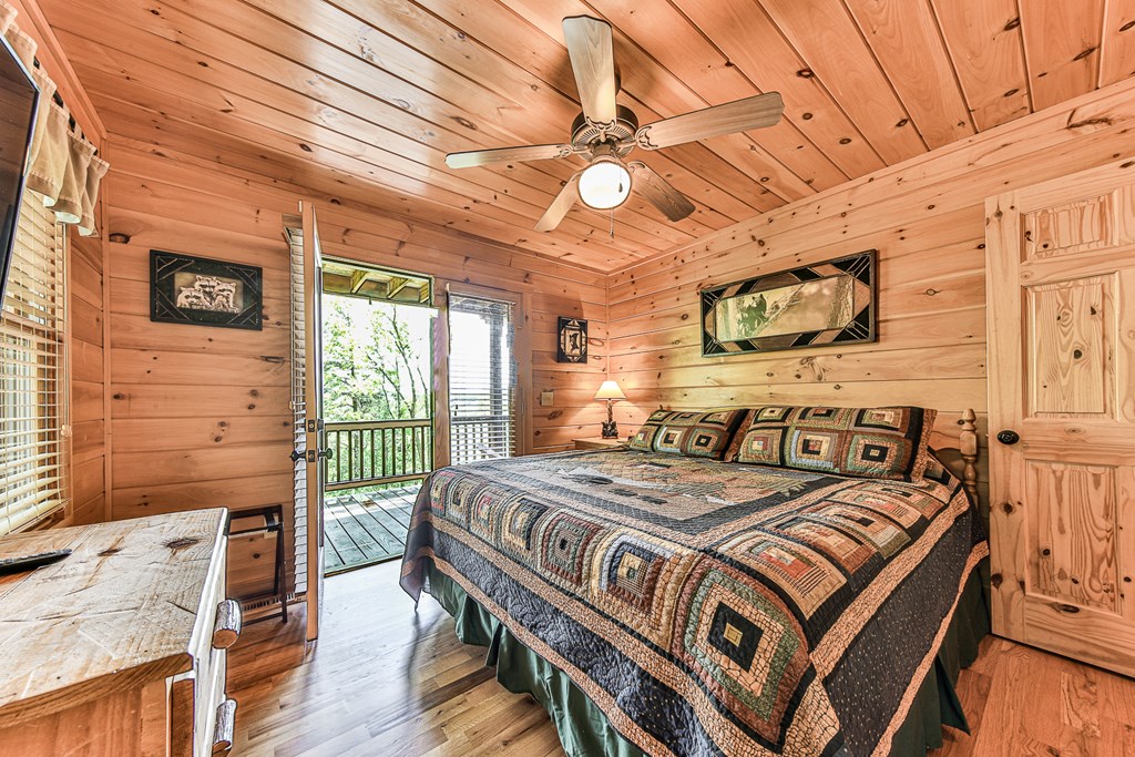 88 Black Gum Lane Blue Ridge, GA 30513 - Photo 26 of 85 a bedroom with a bed next to a window with a flat screen tv