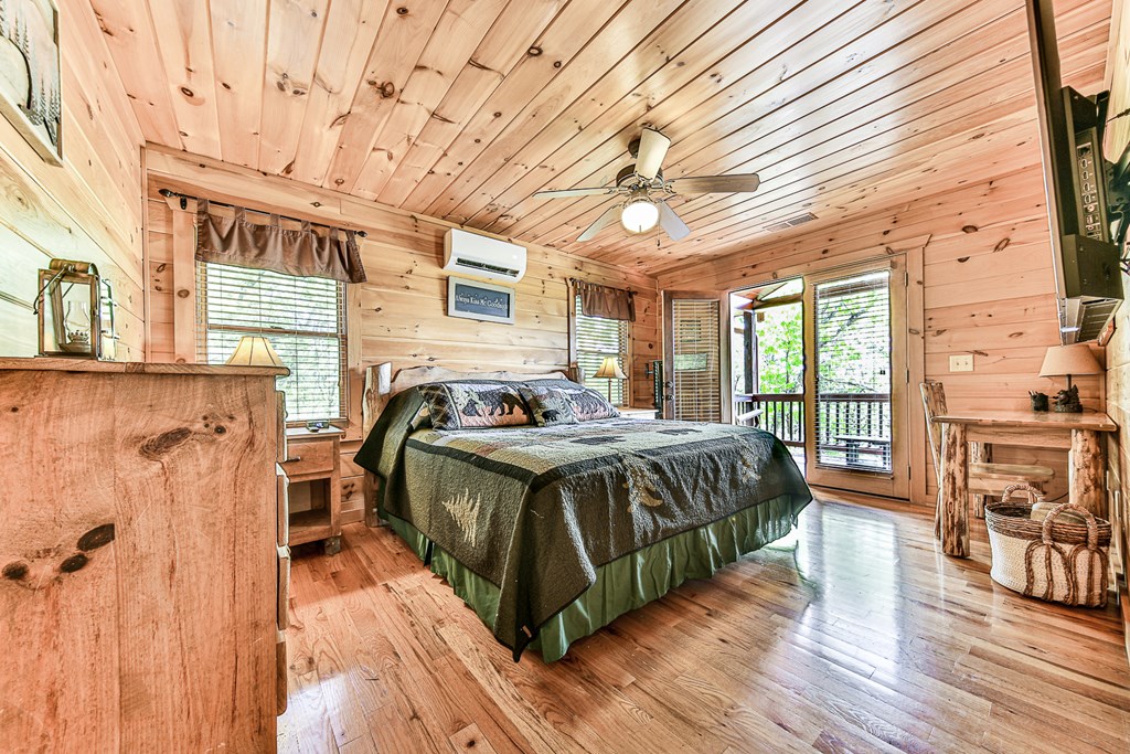 88 Black Gum Lane Blue Ridge, GA 30513 - Photo 30 of 85 a spacious bedroom with a bed a table and wooden floor