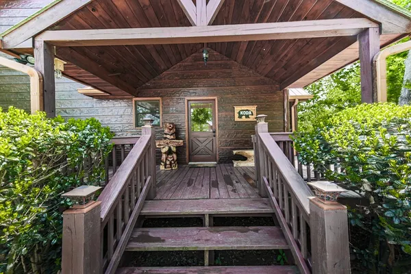 a view of a patio with table and chairs potted plants with wooden floor and fence