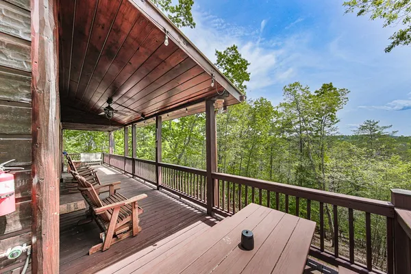 a view of a patio with table and chairs with wooden floor and fence