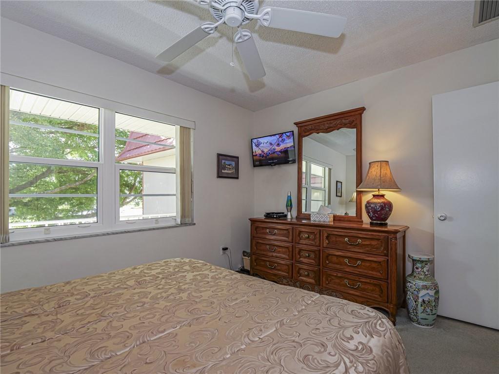 1 Vista Palm Lane, Unit 207 Vero Beach, FL 32962 - Photo 16 of 36 a bedroom with a bed dresser and a window