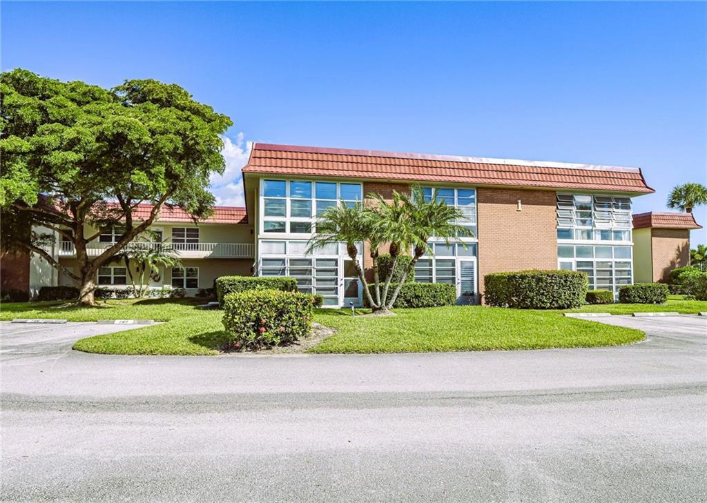 1 Vista Palm Lane, Unit 207 Vero Beach, FL 32962 - Photo 34 of 36 a front view of a house with a yard and trees