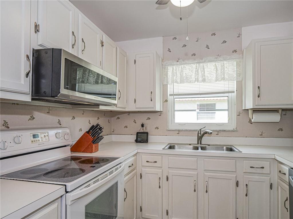 1 Vista Palm Lane, Unit 207 Vero Beach, FL 32962 - Photo 6 of 36 a kitchen with stainless steel appliances granite countertop white cabinets a sink and dishwasher