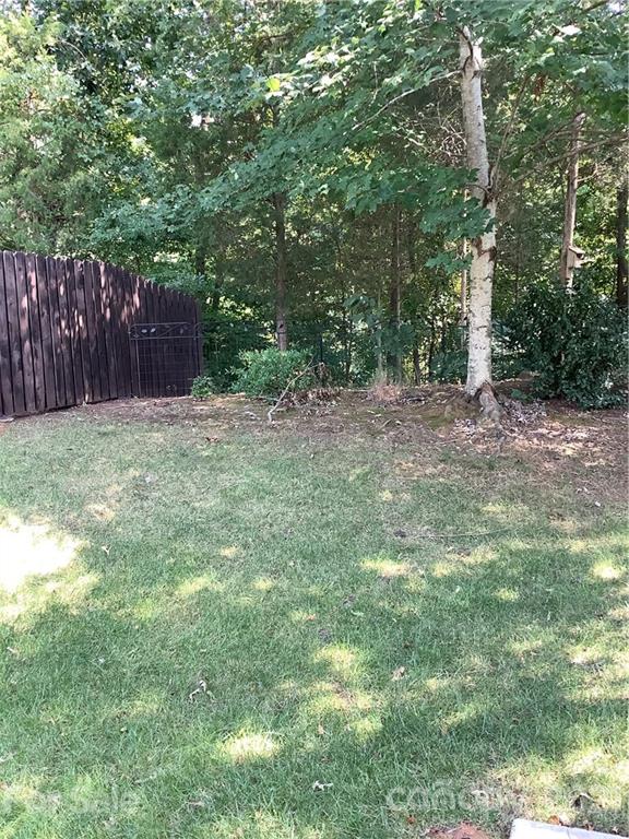388 Sand Paver Way Fort Mill, SC 29708 - Photo 17 of 20 a view of a yard with large trees and wooden fence