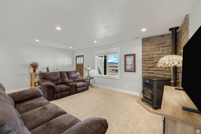 18573 South Marsh Valley Road Downey, ID 83234 - Photo 6 of 32 Living room with a wood stove, light colored carpet, and recessed lighting