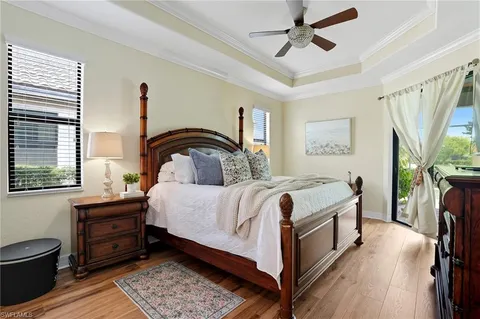 a bedroom with a bed next to a window with wooden floor