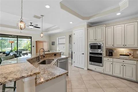 a kitchen with stainless steel appliances granite countertop a sink refrigerator and cabinets