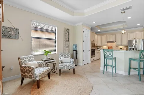 a living room with furniture and a dining table with kitchen view