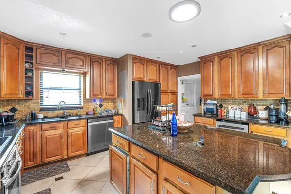 a kitchen with stainless steel appliances granite countertop a sink stove and cabinets