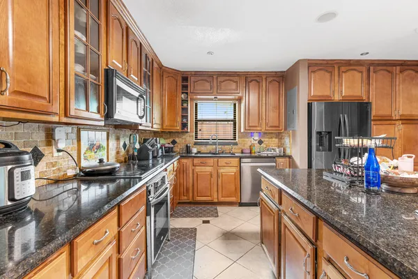a kitchen with stainless steel appliances granite countertop a sink and cabinets