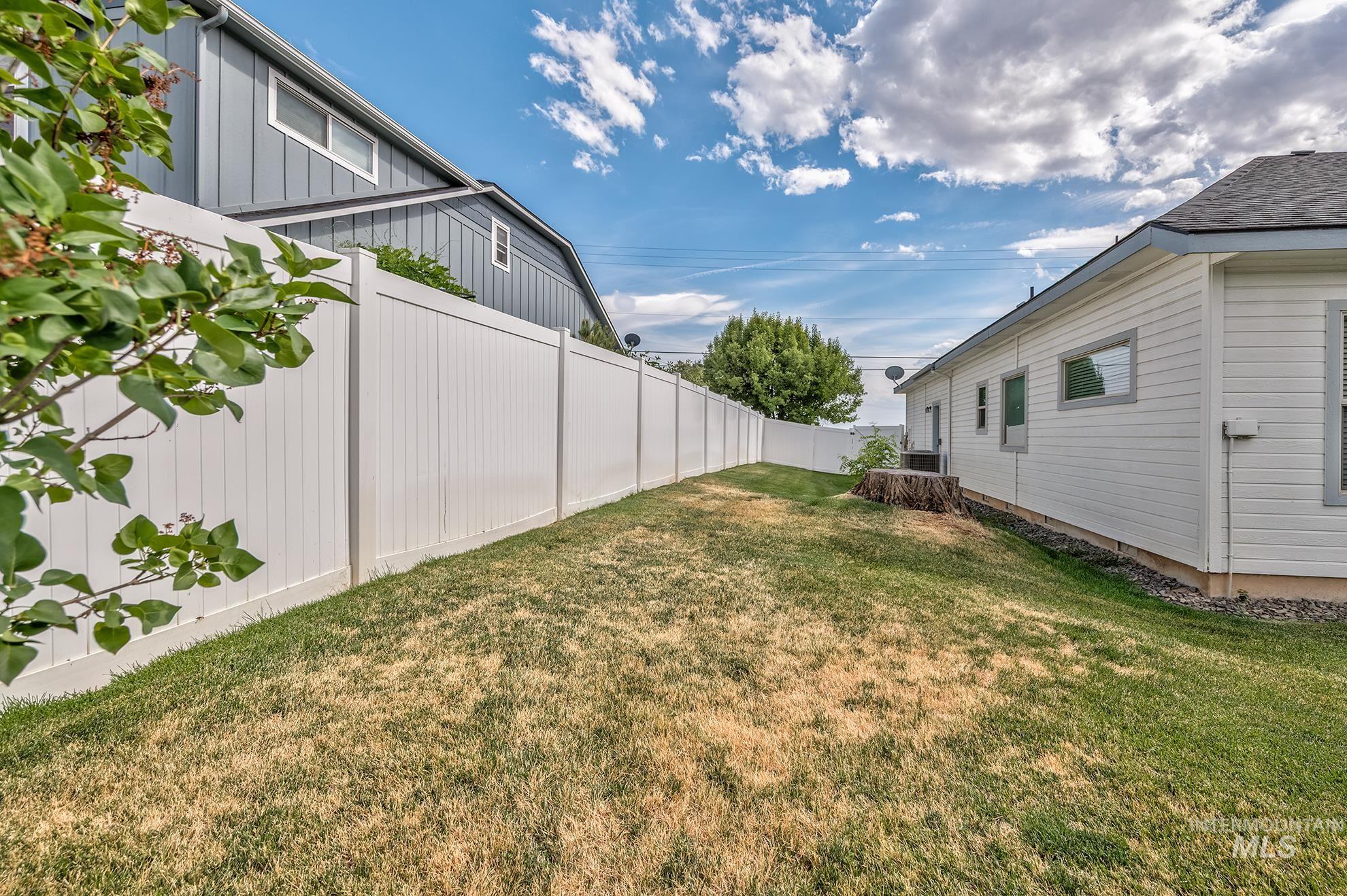 420 West Indianhead Road Weiser, ID 83672 - Photo 37 of 40 Expansive lawn area featuring a tall white privacy fence, a multi-pane window, and horizontal siding