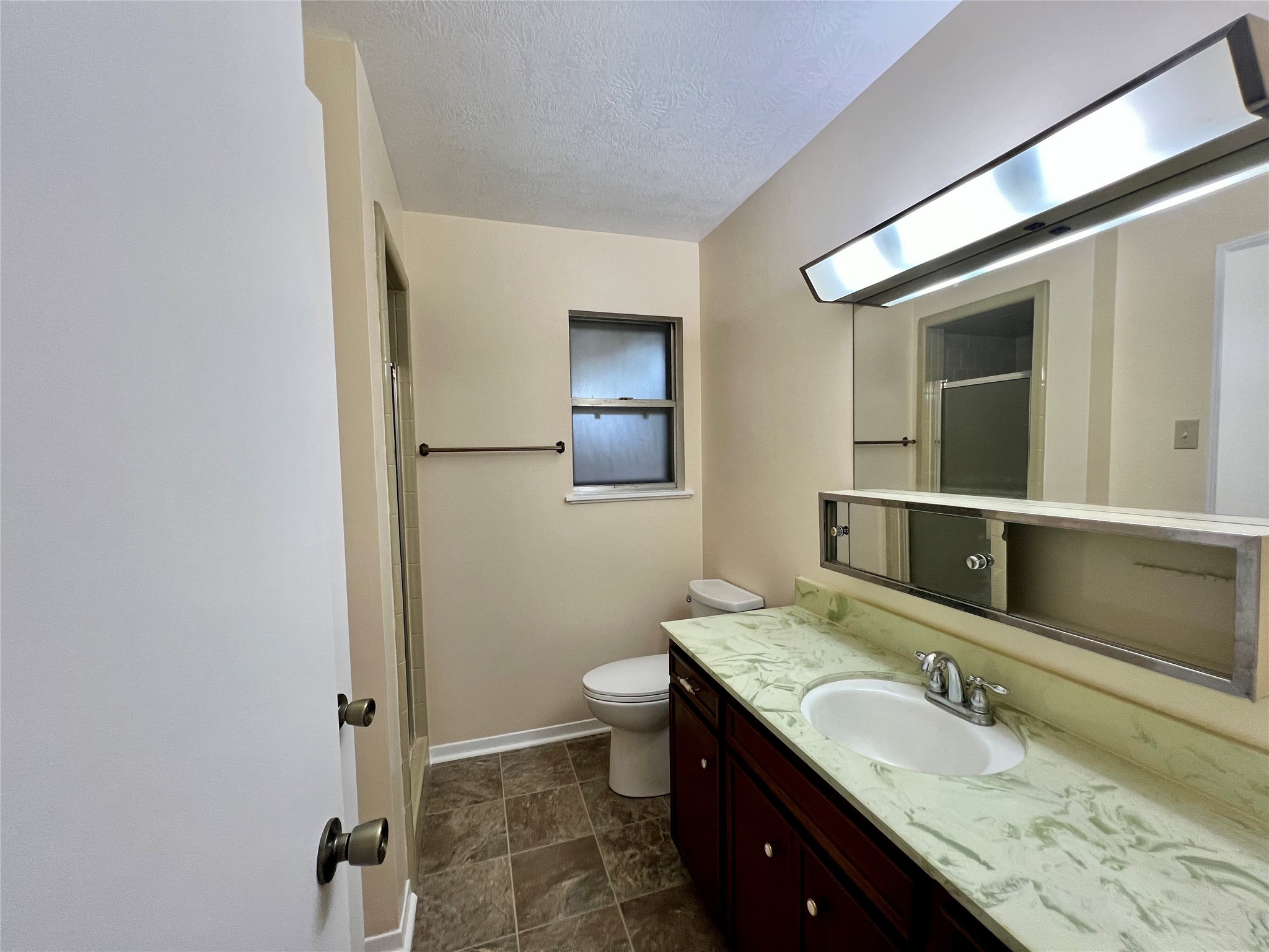 8610 Overhill Lane Beaumont, TX 77707 - Photo 18 of 20 a bathroom with a granite countertop sink a toilet and a mirror