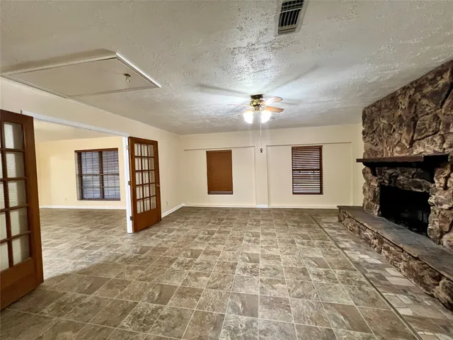 a view of an empty room with window and fireplace