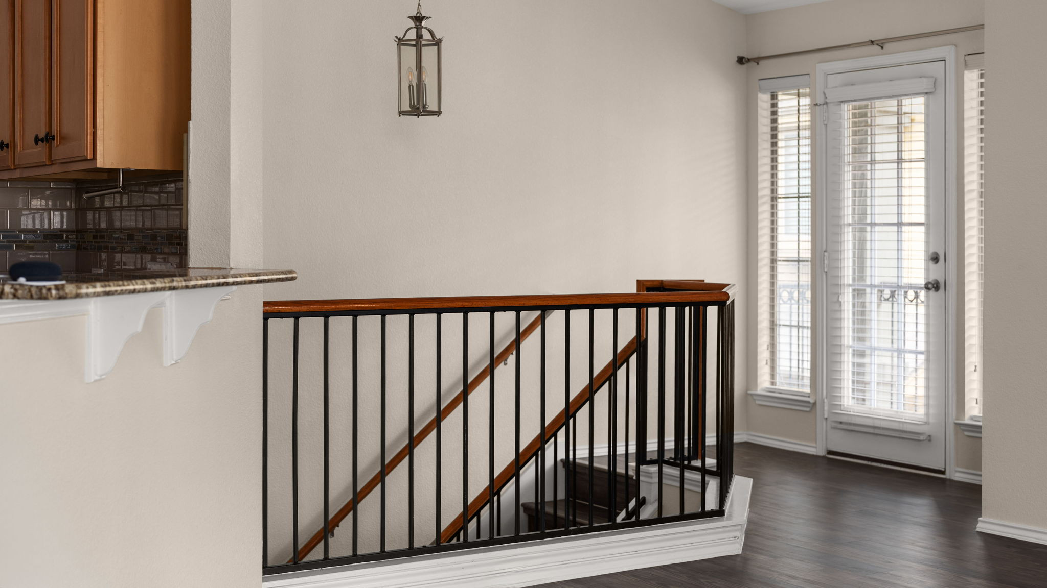 14815 Avery Ranch Boulevard, Unit 1401 Austin, TX 78717 - Photo 6 of 38 Hardwood-finish flooring throughout, complemented by a staircase featuring a dark wood handrail and black metal balusters