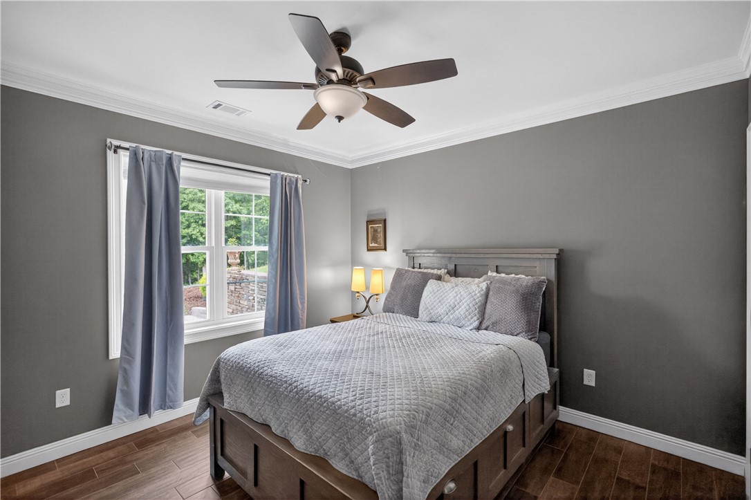 206 James Hare Road Anderson, SC 29626 - Photo 20 of 37 A comfortable bedroom with rich wood flooring and a modern ceiling fan for optimal airflow.