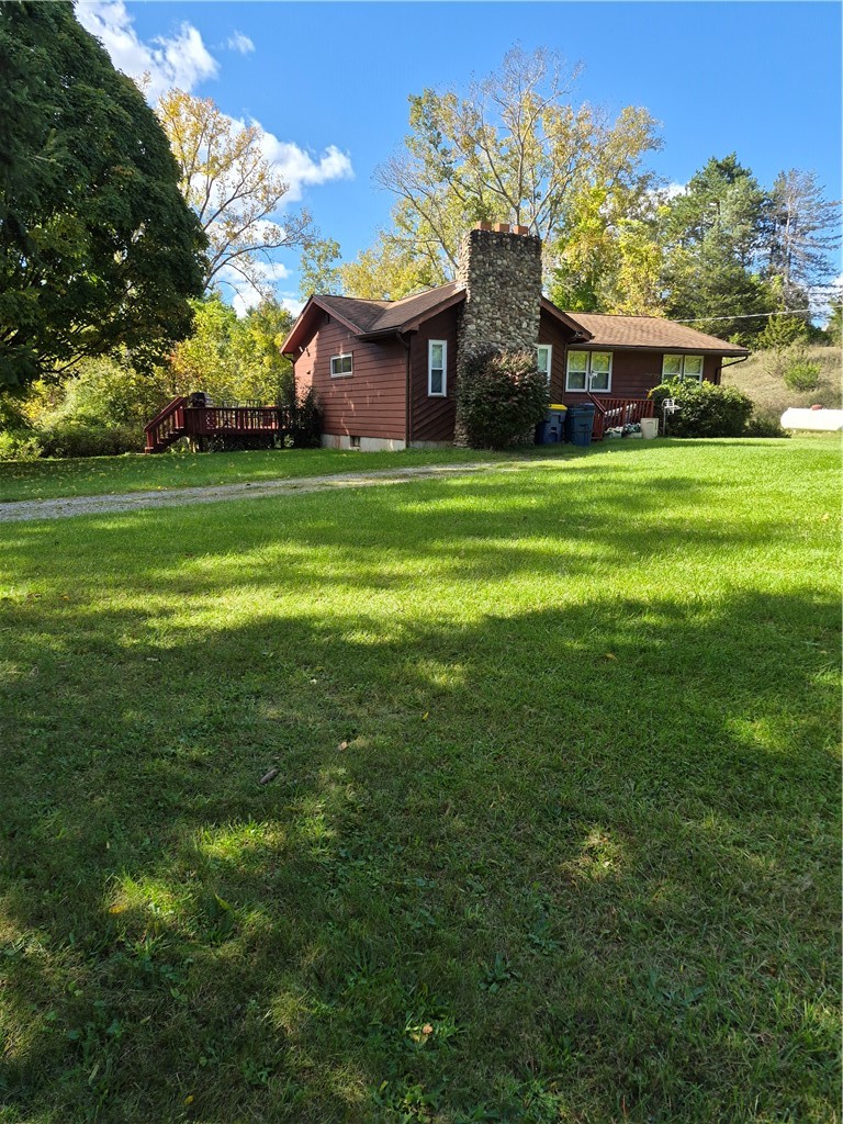 1259 West Bloomfield Road Mendon, NY 14472 - Photo 1 of 24 A spacious green lawn borders this rustic residence featuring a prominent stone chimney.