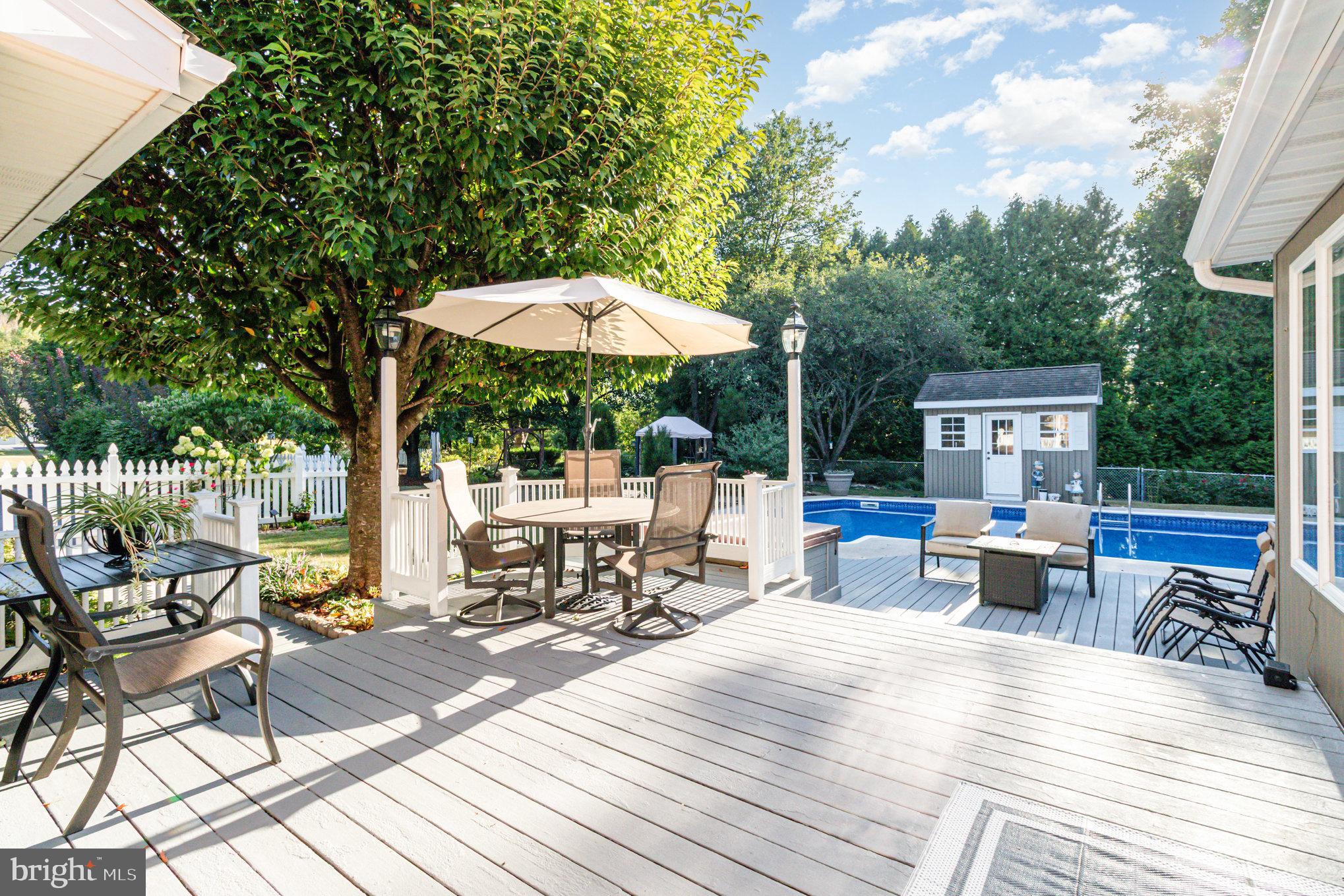 124 South Ridge Road Boiling Springs, PA 17007 - Photo 33 of 56 a view of a patio with a dining table and chairs under an umbrella with a barbeque