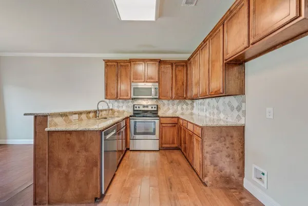 a kitchen with stainless steel appliances granite countertop a sink stove and cabinets