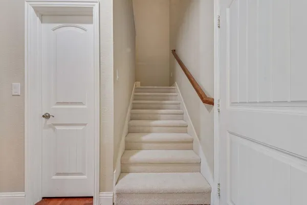 a view of staircase with white walls and white door