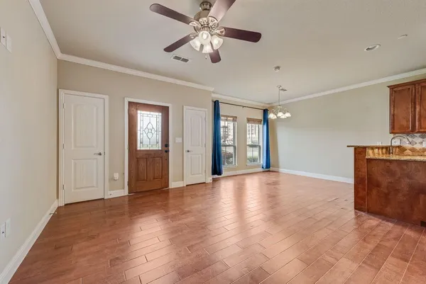 a view of an empty room with window and wooden floor