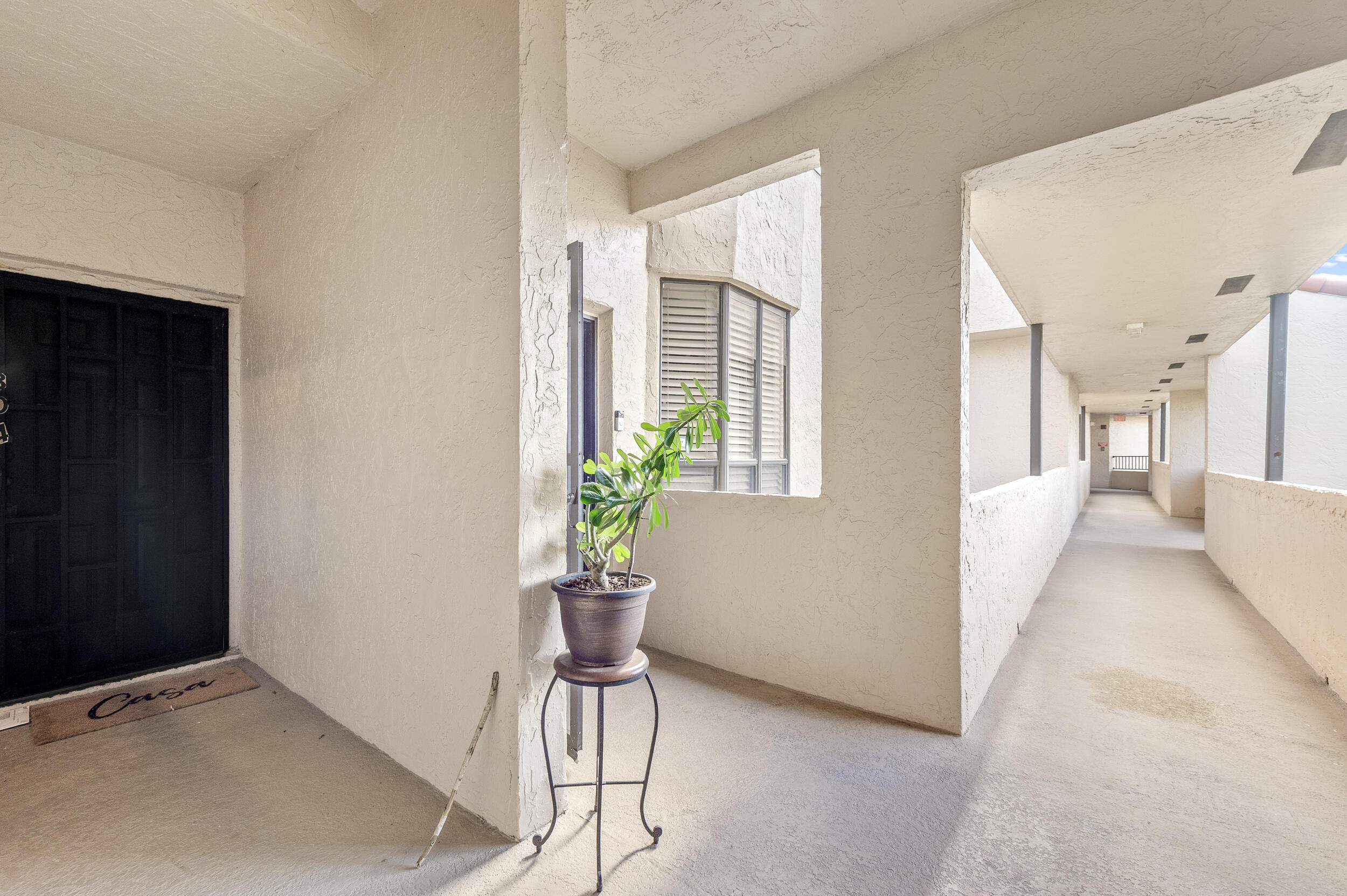 7460 La Paz Boulevard, Unit 304 Boca Raton, FL 33433 - Photo 36 of 37 a living room with furniture and a potted plant