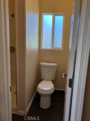 a white toilet sitting in a bathroom next to a sink