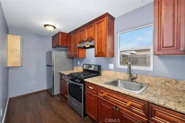 a kitchen with stainless steel appliances granite countertop a sink stove and cabinets