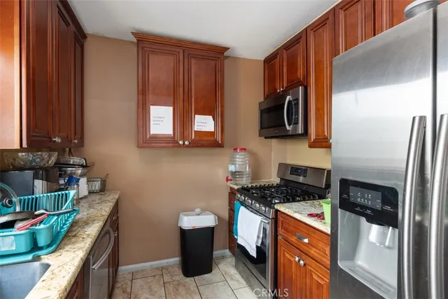 a kitchen with stainless steel appliances granite countertop a stove a sink and a refrigerator