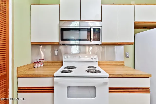 a kitchen with a refrigerator sink stove and microwave
