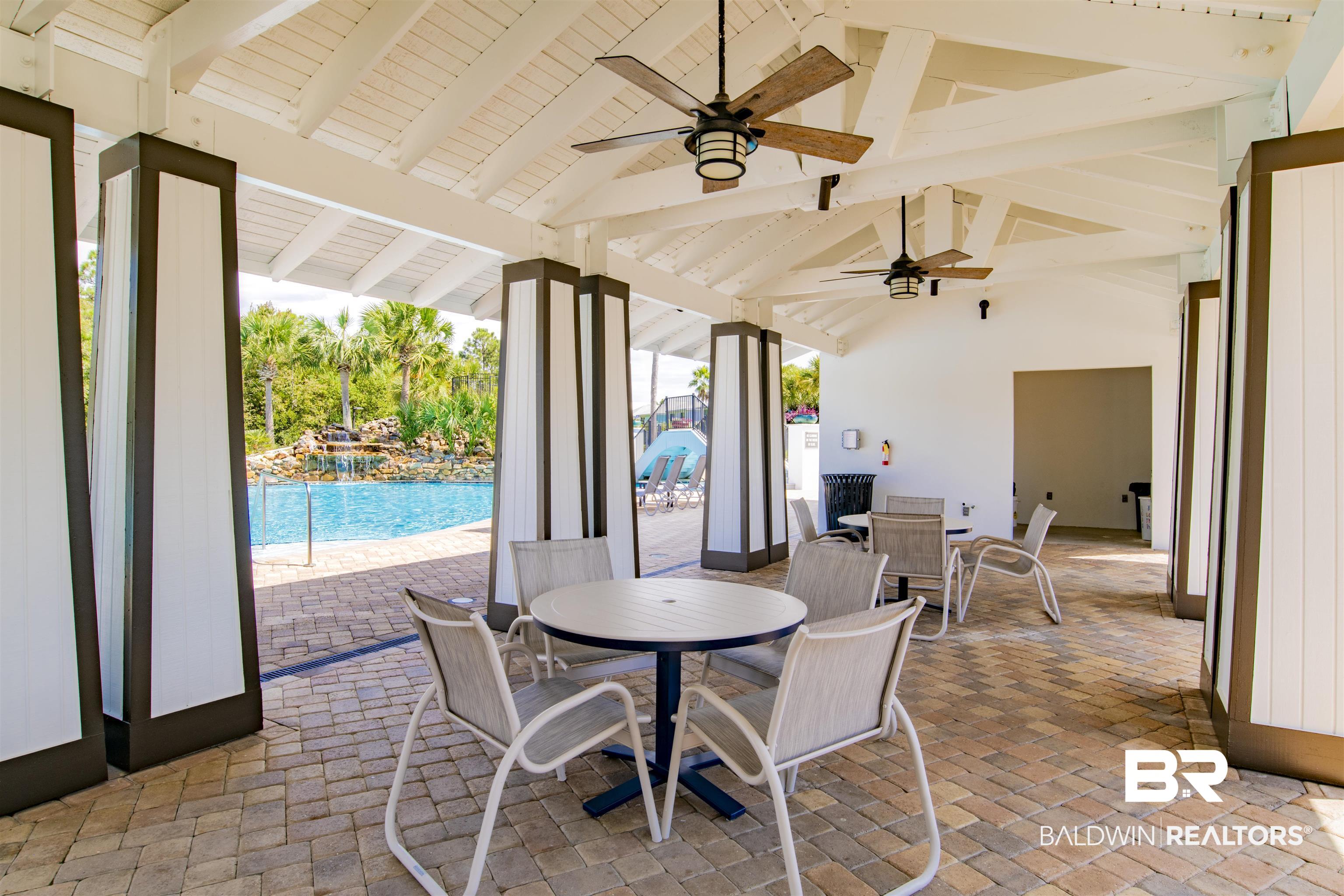 23893 Cypress Crossing Orange Beach, AL 36561 - Photo 15 of 22 View of patio featuring outdoor dining area, a ceiling fan, and an outdoor pool