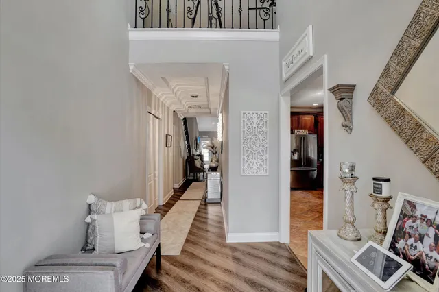a view of a hallway with wooden floor and a living room